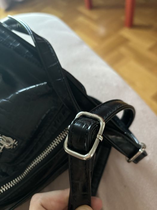 Черна, кажена раница с регулируеми презрамки.