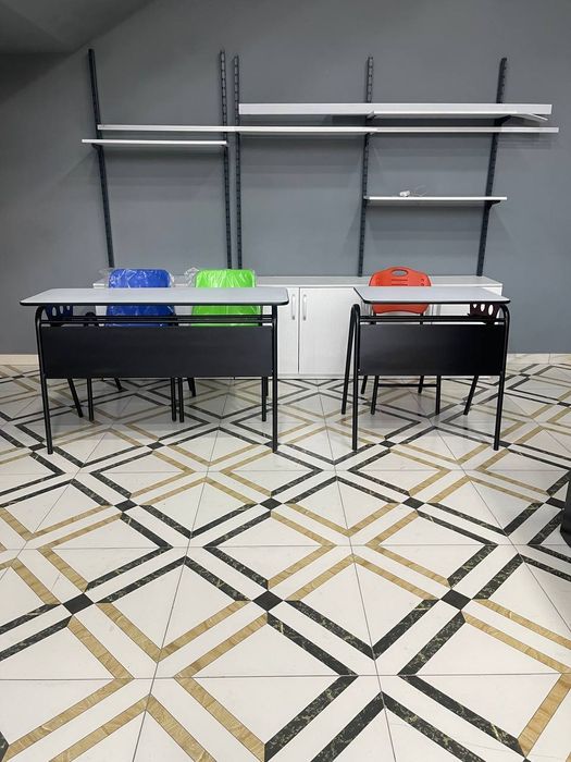 Школьные парты в нейтральных цветах и стулья красочных цветов.