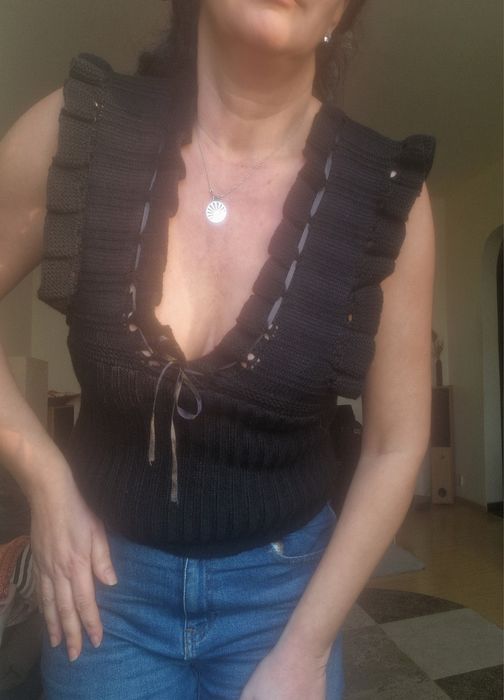 Top model tricotat negru, cu volane la umeri și gat