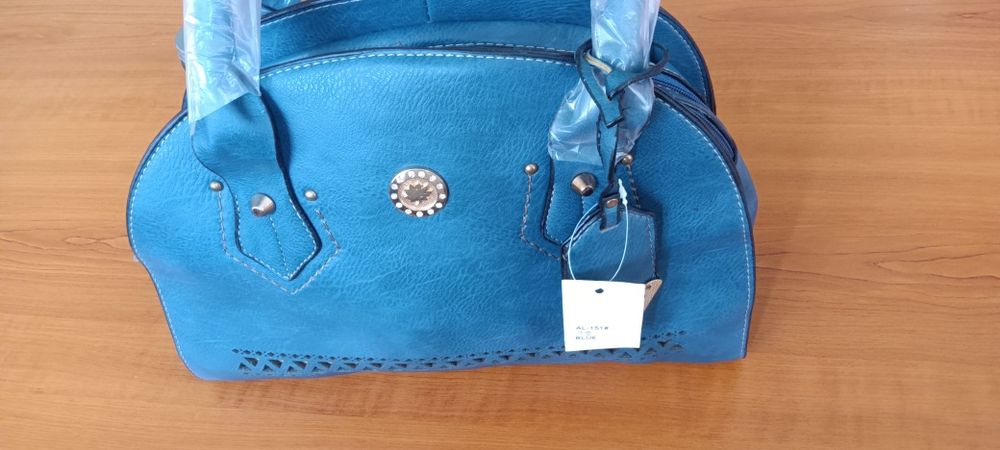 Тъмно синя дамска чанта кожа с две основни дръжки (допълнителна дълга дръжка с регулация) и цип в горната част. С три вътрешни отделения, едното от ко