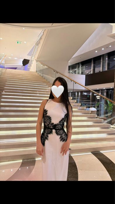 Изящное белое платье с черным кружевным декором по бокам