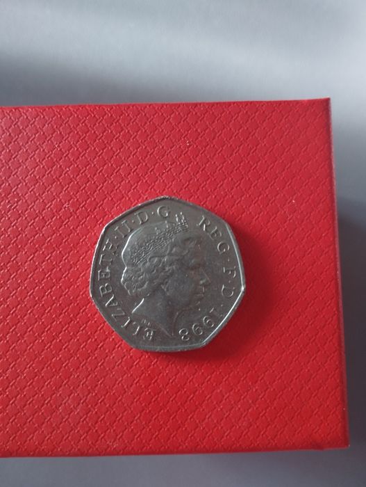 Британская монета номиналом 50 пенсов 1998 года. 
Номинал: 50 пенсов.