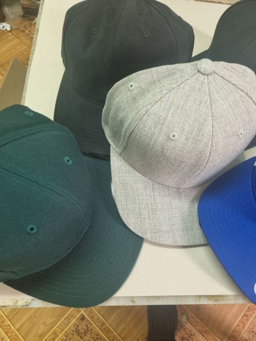 зашиване на емблеми от клиента върху шапки