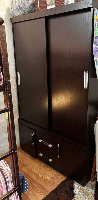 Детская кровать двухэтажная металлическая, шкаф детский и стол.