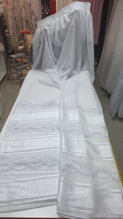Perdeaua oferă un aspect clasic și rafinat, fiind potrivit pentru interioarele care necesită un plus de luminozitate și o notă discretă de strălucire.