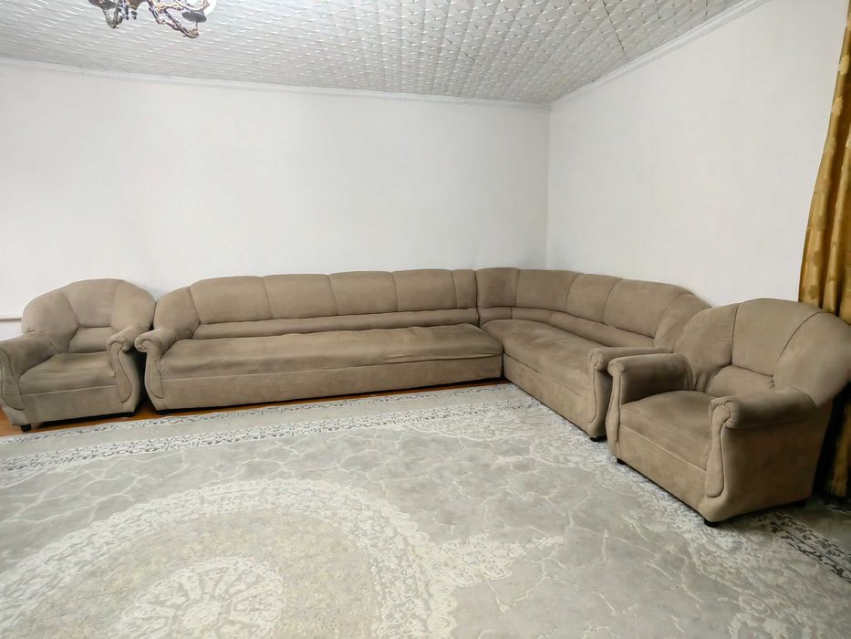 Диван уголок, два кресла и книжный шкаф.