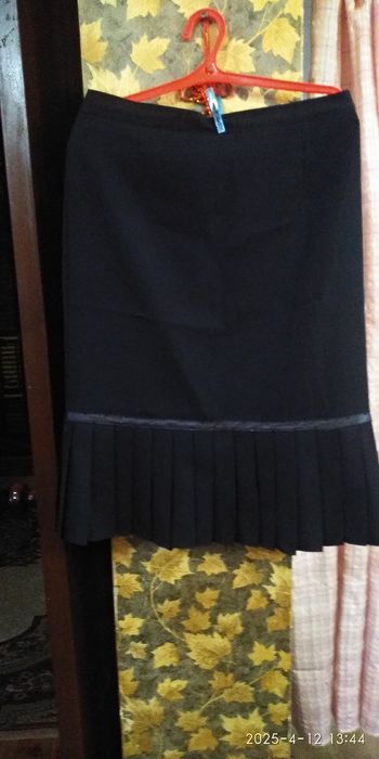 Юбка черная. Внизу складки.
