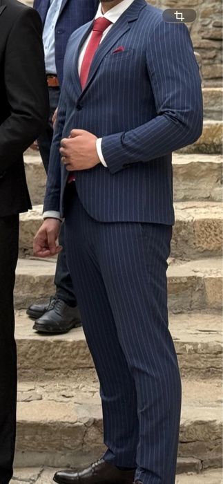 Costum bărbătesc Bigotti, elegant, culoare albastru închis cu dungi albe fine.