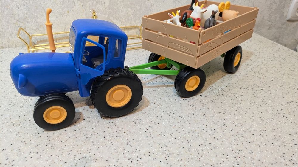 Синий трактор с прицепом и животными