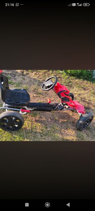 Kart cu pedale roșu pentru copii.