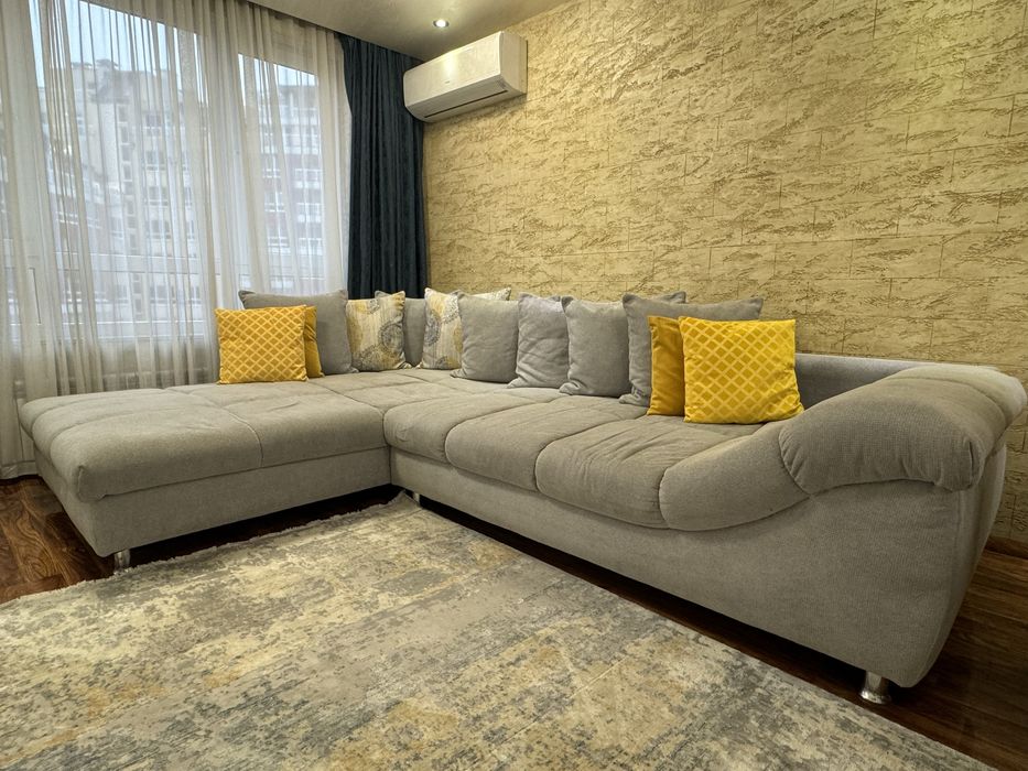 Сив ъглов диван с декоративни възглавници