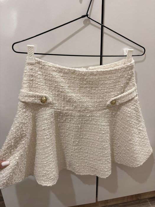 Бяла къса пола с висока талия и разкроен силует.