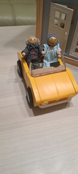 Нова дървена къща с кола и два фигурки