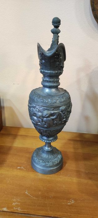 Върху красива стара кана има красиви фигури