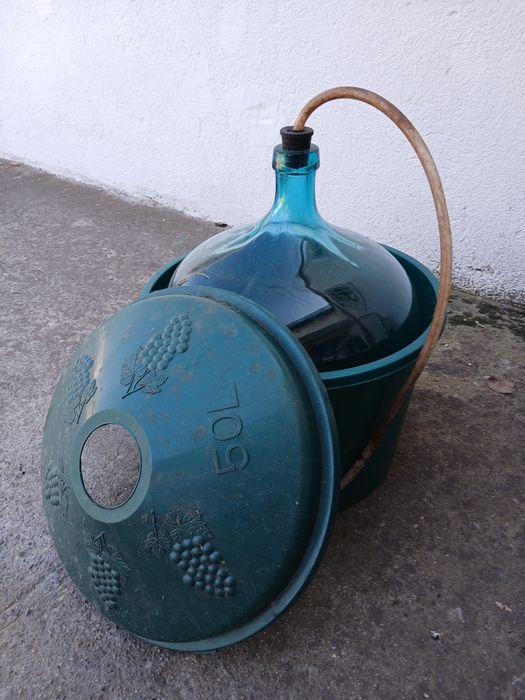 Vând Damigeni din Sticlă în Coș de Plastic – 5 bucăți de 50L și 1 bucată de 25L