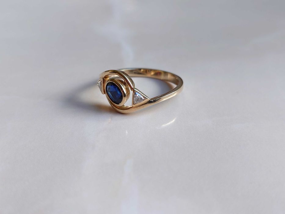 Inel Aur de 18 k cu 2 diamante Trillion Cut si un safir albastru.