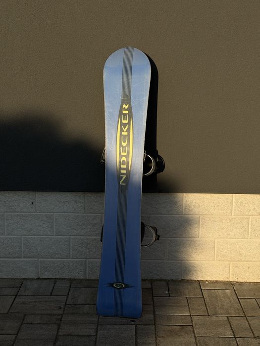 Snowboard Nidecker model Rave, echipată cu legături.