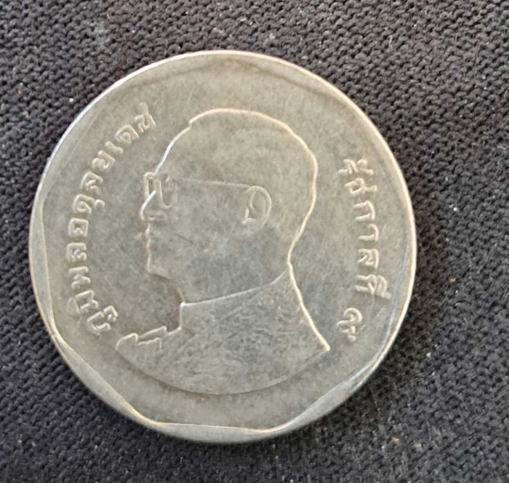 Тайландска монета с номинал 5 бата. На лицевата страна е изобразен крал Рама IX, а на обратната страна е храмът Ват Бенджамабопит.