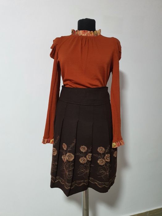 Fusta cu pliuri, material cu tinuta, cu flori cusute manual;