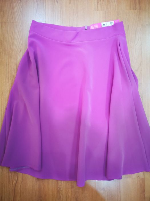 Fusta din stofa, ușor elastica, mov, în cloș, cu buzunare. Mărime L