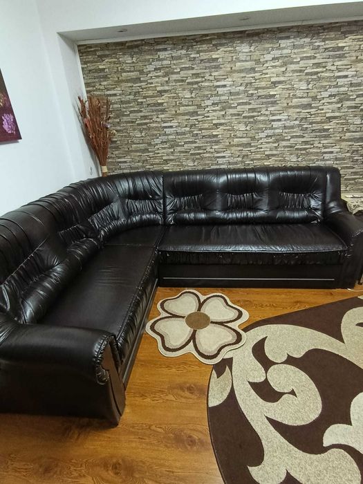 Vand coltar extensibil impreuna cu un fotoliu din piele neagra.