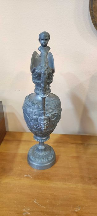 Върху красива стара кана има красиви фигури