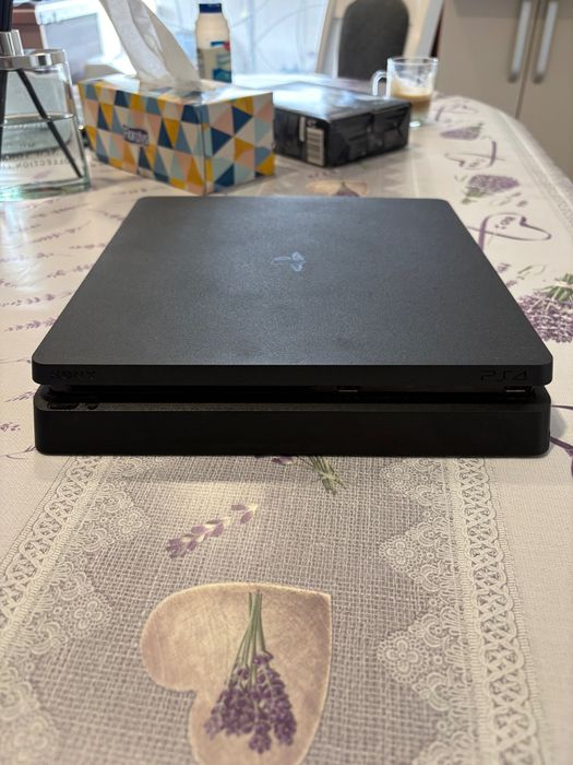Vând PS4 Slim în stare bună.  Consola funcționează fără probleme. Vine însoțită de: - 1 manetă (controller) - jocurile: The Last of Us Part I, part 2