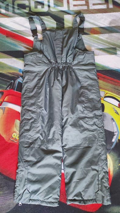 Vand pantaloni de schi cu bretele, pentru copii, de culoare gri.