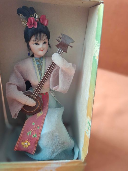 Păpușă decorativă tradițională chinezească, realizată manual în stil vintage, reprezentând o femeie care cântă la un instrument muzical cu coarde