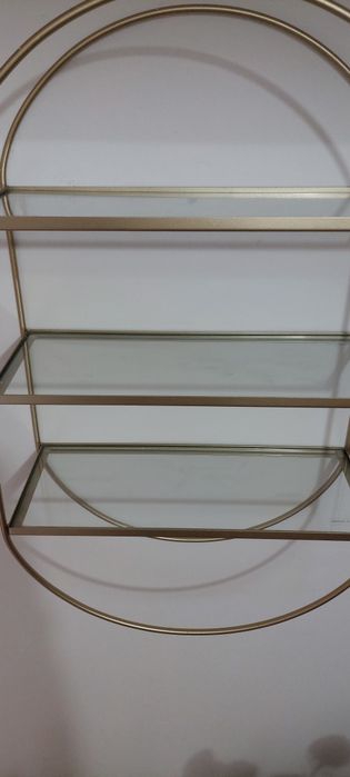 Etajera metalica cu rafturi din sticlă.