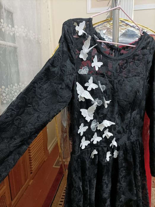 Qora ko'ylak oldi qismiga kapalekla bilan ishlov berilgan