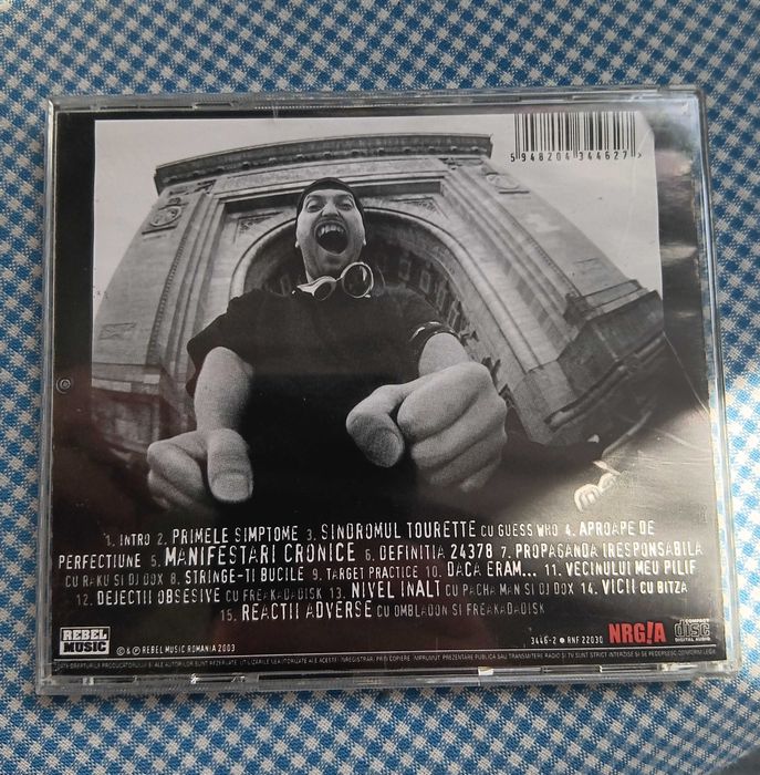 CD Cheloo, intitulat „Sindromul Tourette”, lansat în 2003 prin casa de discuri Rebel Music, Muzica Hip Hop Romanesc