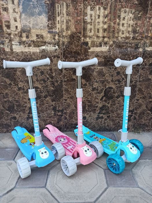 Yorqin g'ikdidiraklari bolgan bolalar uch gikdirakli skuter