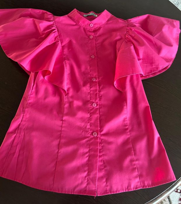 Яркая блузка с объемными рукавами.