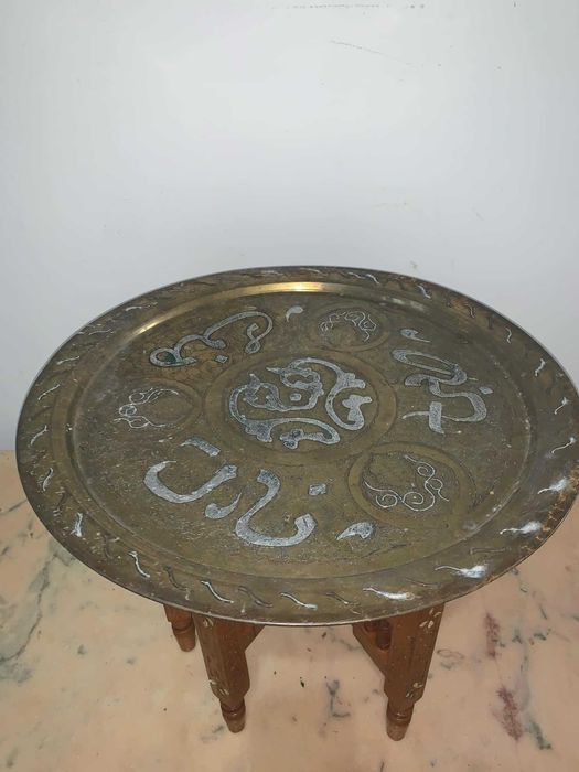 Masuta arabeasca cu blat alama gravata asezata pe suport de lemn