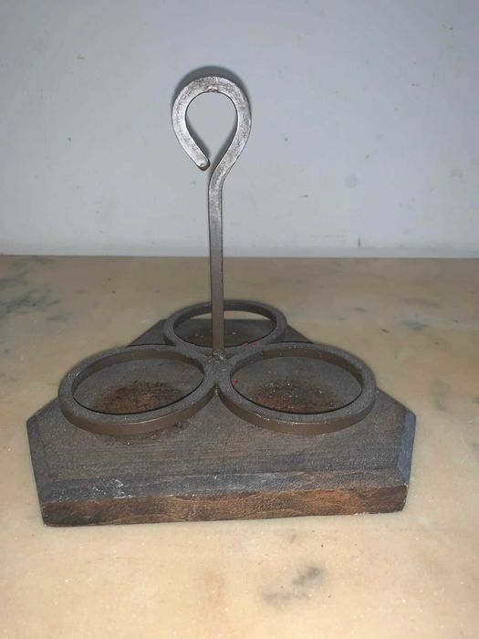 Suport de trei lumanari din fier forjat asezat pe suport de lemn