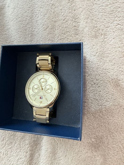 Стилен дамски часовник Tommy Hilfiger в златист цвят. Много запазен, с оригинална кутия. Подходящ за ежедневие и официални поводи.