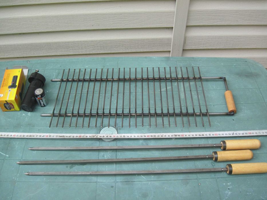 Барбекю на дървени въглища с въртящи се шишове и скара.