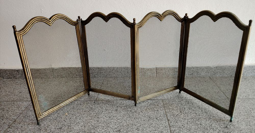 Paravan pentru șemineu din plasă neagră, format din 4 panouri amplasate într-un cadru de alamă.