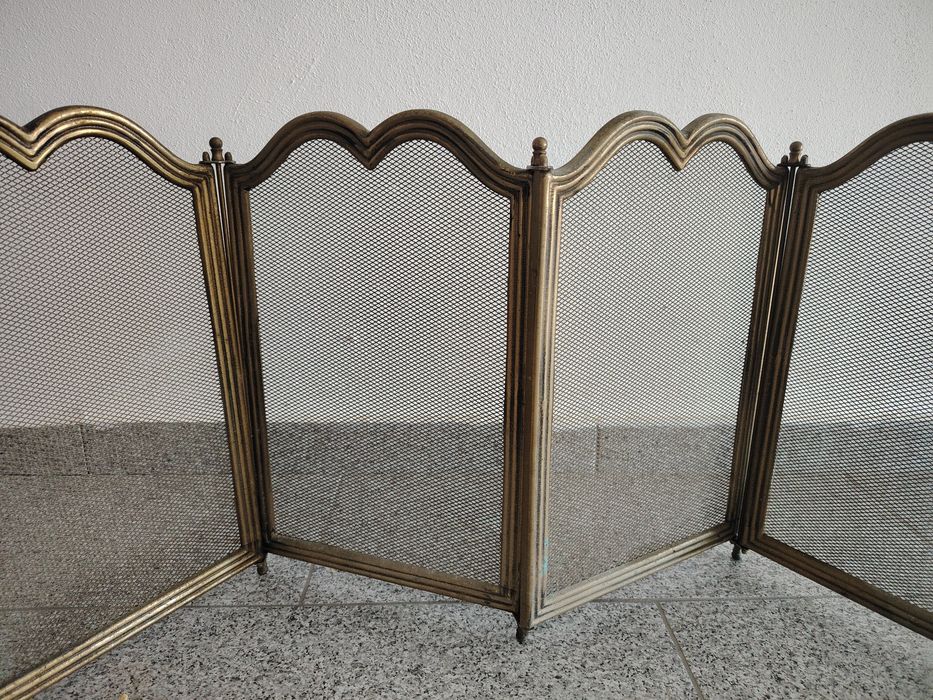 Paravan pentru șemineu din plasă neagră, format din 4 panouri amplasate într-un cadru de alamă.