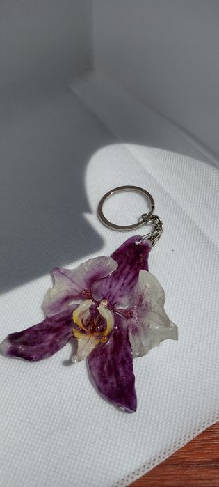 Ключодържател или аксесоар за чанта с естествен цвят на орхидея.