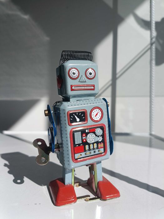 Робот, тенекиена играчка, навива се с ключ и се движи.