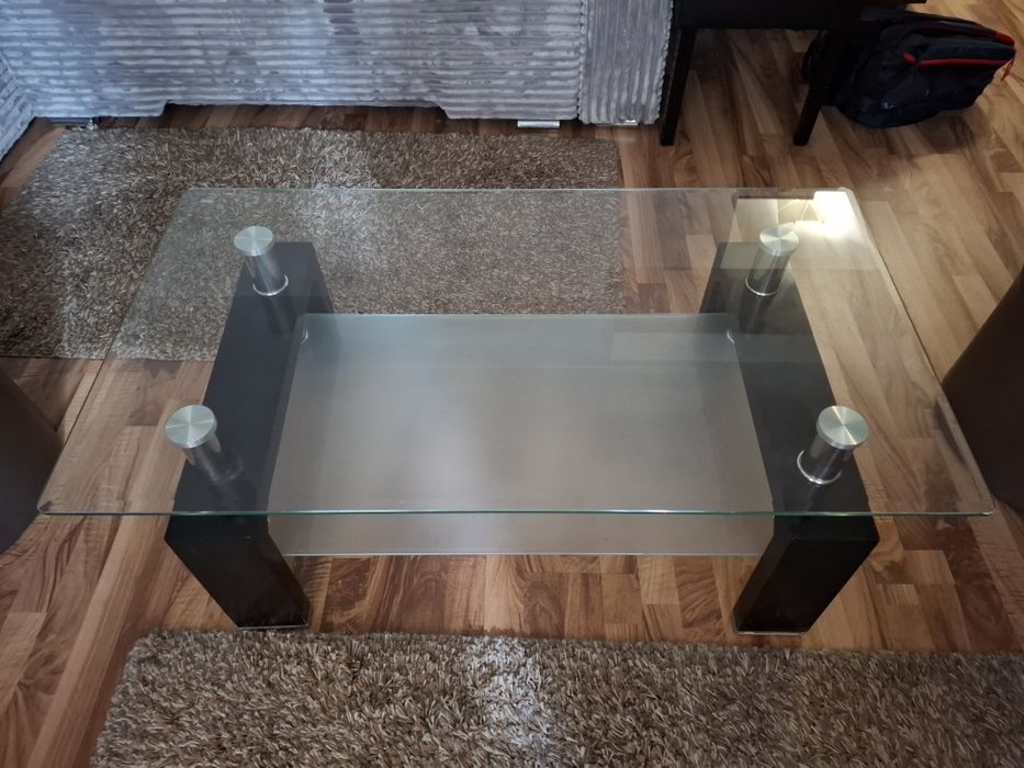 Măsuță de cafea modernă, realizată dintr-o combinație de sticlă, metal și lemn .