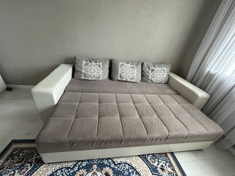 Диван серого цвета с белыми кожаными подлокотниками