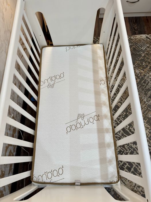 Люлеещо дървено легло с матрак и чекмеджета за съхранение.