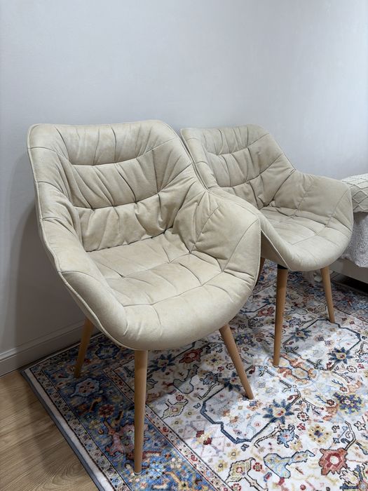 Кресло, обитое тканью, с ножками из натурального дерева.