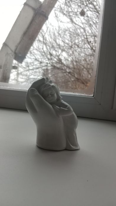 Гипсовый малыш в руке