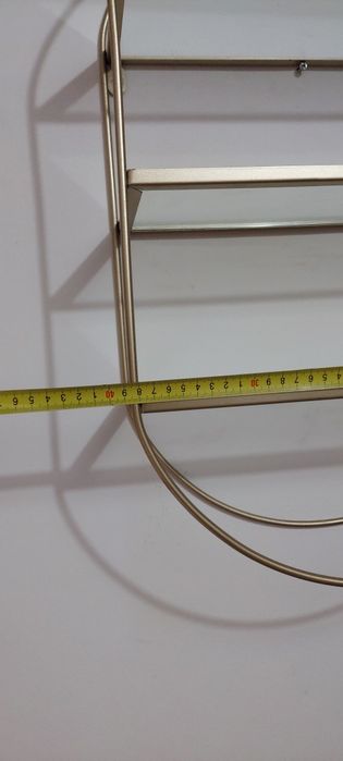 Etajera metalica cu rafturi din sticlă.