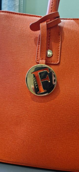 Чанта FURLA Linda S Tote, Ruby
Носена е няколко пъти,но е малко по-голяма от колкото очаквах.
 Размери:31×22.5-23×13-14 cm
Цената е 60 €