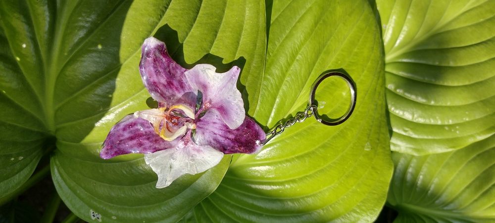 Ключодържател или аксесоар за чанта с естествен цвят на орхидея.